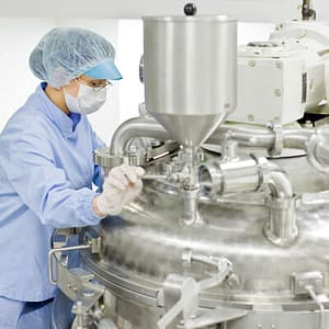 Operator handling chemical reactor in pharmaceutical plant